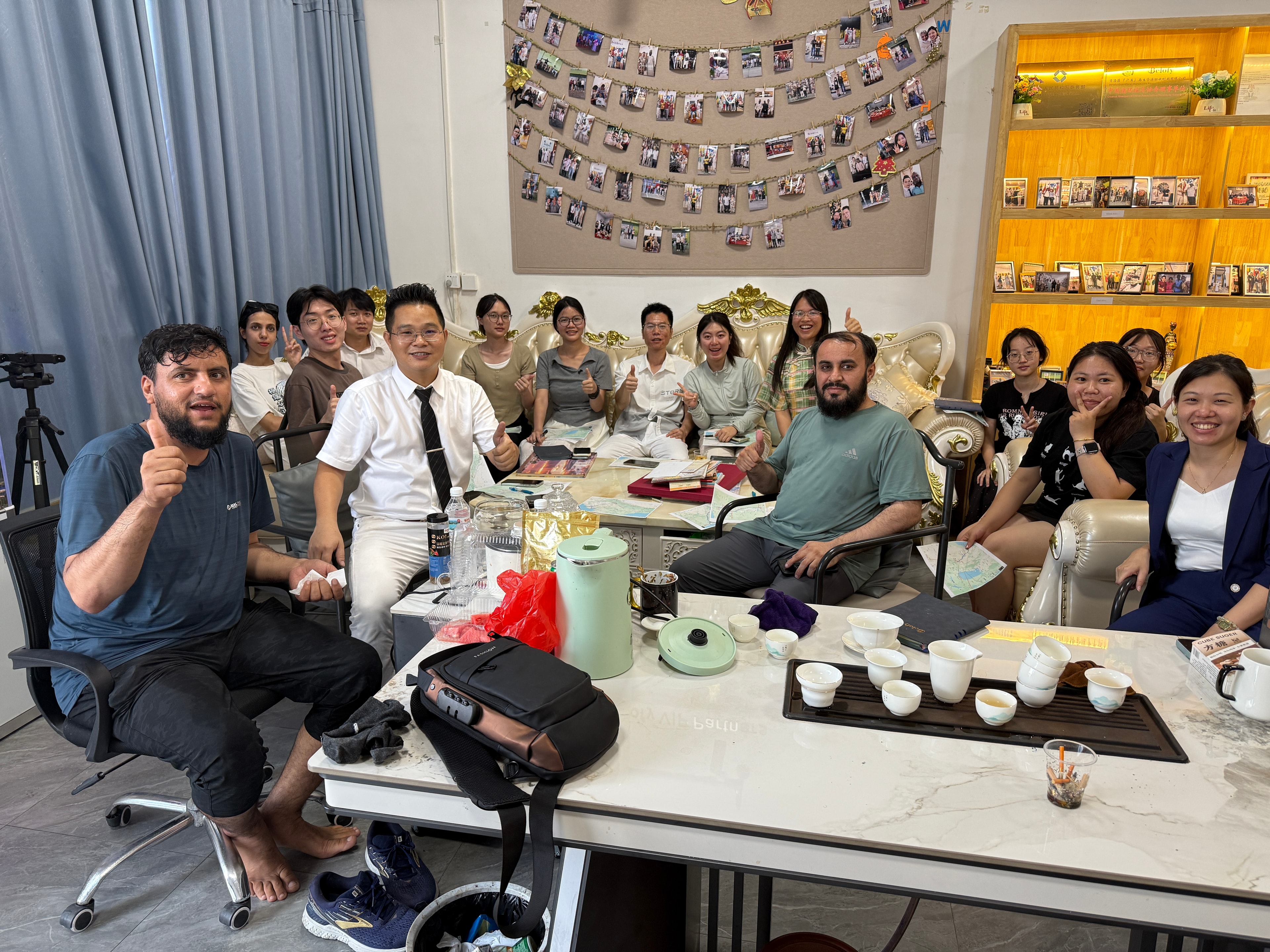 Large group gathering indoors smiling together Belofy team